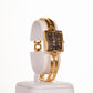 AW dámske hodinky vo farbe zlata s čiernym ciferníkom s rímskymi číslicami
